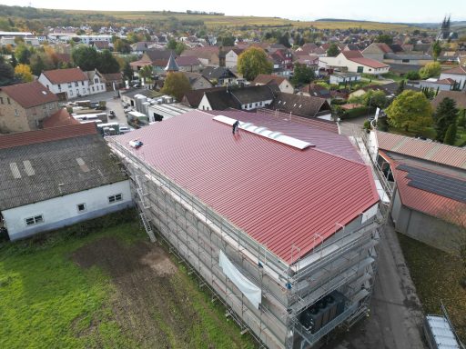 Weingut Dohlmühle Flonheim Dach eines Gebäudes im Bau, umgeben von einer Stadtlandschaft.