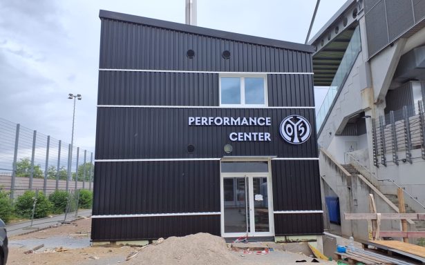 Performance Center 1.FSV Mainz 05 Schwarzes Gebäude mit Beschriftung "PERFORMANCE CENTER" und Fenster.
